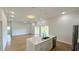 Open-concept living space with wood floors, island seating, modern lighting, and sliding glass doors at 6741 Heavitree Dr, Sebring, FL 33876