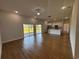Open-concept living room with sliding glass doors, wood-look floors, and modern lighting at 6741 Heavitree Dr, Sebring, FL 33876