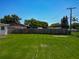 Green backyard with a tall wood fence and mature trees beyond the property line at 8228 Shriver Dr, Orlando, FL 32822