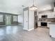 Open kitchen with white cabinets, stainless steel appliances, light wood-look floors and view of the living room at 8228 Shriver Dr, Orlando, FL 32822