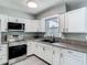 Close up of updated kitchen featuring stainless steel appliances, sink and granite countertops at 8228 Shriver Dr, Orlando, FL 32822