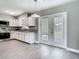 Modern kitchen featuring white cabinets, granite countertops, stainless steel appliances, and light wood-look floors at 8228 Shriver Dr, Orlando, FL 32822