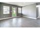 Bright living room with grey walls, white trim, recessed lighting, light wood-look floors, and an exterior door at 8228 Shriver Dr, Orlando, FL 32822