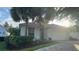 Charming home with a red tile roof and mature landscaping, including palm trees at 8532 Bay Springs Dr, Orlando, FL 32819