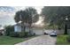 Well-maintained home featuring a two-car garage, brick driveway, and lush landscaping at 8532 Bay Springs Dr, Orlando, FL 32819