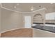 Bright interior showcasing the kitchen area with wooden floors, archway shelving, black countertops, and white cabinets at 860 N Orange Ave # 306, Orlando, FL 32801
