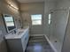 Bathroom features a double vanity with white countertops and a tiled walk-in shower at 8600 Castile Rd, Sebring, FL 33876