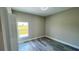 Cozy bedroom featuring wood-look floors, a bright window, and neutral wall paint at 8600 Castile Rd, Sebring, FL 33876
