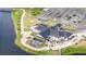 An aerial view showcases the clubhouse with a large deck, parking, and golf cart spaces near the water at 8600 Castile Rd, Sebring, FL 33876
