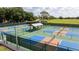 A high-angle view showcasing community sport courts with shaded seating areas surrounded by lush greenery at 8600 Castile Rd, Sebring, FL 33876