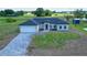 New construction home boasts a sprawling lawn, driveway, attached garage, and neutral color palette at 8600 Castile Rd, Sebring, FL 33876
