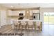 Modern kitchen features white cabinets, stainless steel appliances, large island with seating and pendant lighting at 8600 Castile Rd, Sebring, FL 33876