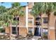 Well-maintained condo building exterior with palm trees and a staircase leading to upper units at 8801 Latrec Ave # 8101, Orlando, FL 32819
