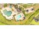 Aerial view of community pool area with umbrellas and shaded seating areas at 8801 Latrec Ave # 8101, Orlando, FL 32819