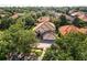 An aerial shot captures a spacious home with mature trees, a well-manicured lawn, and a paved driveway at 9128 Phillips Grove Ter, Orlando, FL 32836