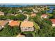 Aerial view of the neighborhood with lush trees and a lake in the distance at 9128 Phillips Grove Ter, Orlando, FL 32836