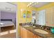 A connecting bathroom featuring double sinks with granite countertops and vanity at 9128 Phillips Grove Ter, Orlando, FL 32836