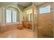 Bright bathroom featuring a soaking tub under a window, and a glass enclosed shower at 9128 Phillips Grove Ter, Orlando, FL 32836