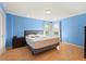 Bedroom featuring blue walls, two windows with curtains, and light wood flooring at 9128 Phillips Grove Ter, Orlando, FL 32836
