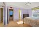 Bedroom has light purple walls, wood floors and an attached bathroom at 9128 Phillips Grove Ter, Orlando, FL 32836