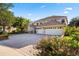 A beautiful house featuring a brick-paved driveway, a three-car garage, and well-maintained landscaping at 9128 Phillips Grove Ter, Orlando, FL 32836