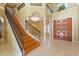 Open entry foyer with staircase and tile floors, plus wooden doors at 9128 Phillips Grove Ter, Orlando, FL 32836