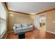 Comfortable living room showcasing wood floors, soft lighting, a cozy couch, and an open doorway to the dining area at 9128 Phillips Grove Ter, Orlando, FL 32836