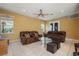 Inviting living room showcasing tile floors, neutral walls, a ceiling fan, and comfortable leather seating at 9128 Phillips Grove Ter, Orlando, FL 32836