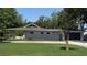 View of the rear of the house with a modern fence, well-kept lawn, and mature trees at 954 N Texas Ave, Orlando, FL 32804
