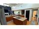 Well-lit kitchen featuring a granite island with cooktop, stainless steel appliances, and hardwood floors at 954 N Texas Ave, Orlando, FL 32804