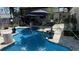 Sparkling swimming pool surrounded by a paver patio with lush tropical landscaping, and sun umbrella at 954 N Texas Ave, Orlando, FL 32804