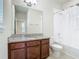Well lit bathroom featuring granite countertops, a soaking tub with shower, and neutral tile flooring at 9971 Beach Port Dr, Winter Garden, FL 34787