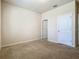 A well-lit bedroom with neutral carpet and baseboards, and white doors at 9971 Beach Port Dr, Winter Garden, FL 34787