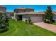 Two-story home featuring manicured lawn, brick driveway, and attached two-car garage at 9971 Beach Port Dr, Winter Garden, FL 34787