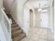Bright foyer featuring tile flooring, a staircase, and a clear view of the front door at 9971 Beach Port Dr, Winter Garden, FL 34787
