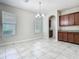 Kitchen features tile floors, granite counters, and brown cabinets with a chandelier at 9971 Beach Port Dr, Winter Garden, FL 34787