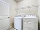 Bright laundry room with white appliances and wire rack shelving at 9971 Beach Port Dr, Winter Garden, FL 34787