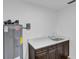 A laundry room features a stainless steel sink, cabinets, and Rheem hot water heater at 1050 20 St, Orlando, FL 32805