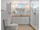 This bathroom features a double sink vanity, granite countertop, and glass enclosed shower at 1064 Universal Rest Pl, Kissimmee, FL 34744