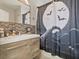 This is a uniquely decorated bathroom featuring a modern vanity and themed shower curtain at 1064 Universal Rest Pl, Kissimmee, FL 34744