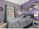 This is a charming bedroom with a large window and soothing purple walls at 1064 Universal Rest Pl, Kissimmee, FL 34744