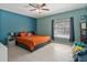 Cozy bedroom with an orange quilted bed, ceiling fan, and natural light, creating a peaceful and inviting retreat at 1064 Universal Rest Pl, Kissimmee, FL 34744