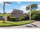 Community entrance featuring a monument sign, colorful landscaping, and mature trees at 1111 High Vista Dr, Davenport, FL 33837