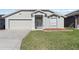 Well-maintained home with a green lawn, mulch landscaping, and a two-car garage at 1111 High Vista Dr, Davenport, FL 33837