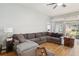 Bright living area features wood floors, a large sectional, and sliding glass doors at 1111 High Vista Dr, Davenport, FL 33837