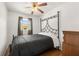 Bright bedroom features hardwood floors, updated ceiling fan, and wrought iron bed frame at 1125 Emerald Dr, Mount Dora, FL 32757