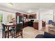 Functional kitchen with dark wood cabinets, black appliances, adjacent dining area and a large window at 1125 Emerald Dr, Mount Dora, FL 32757