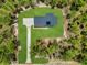Aerial view of modern farmhouse, long driveway and mature trees at 12193 Sw 69 Pl, Ocala, FL 34481