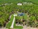 Stunning aerial view of modern farmhouse on acreage with mature trees at 12193 Sw 69 Pl, Ocala, FL 34481
