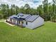 Beautiful modern farmhouse featuring board and batten siding, black trim, and mature trees at 12193 Sw 69 Pl, Ocala, FL 34481